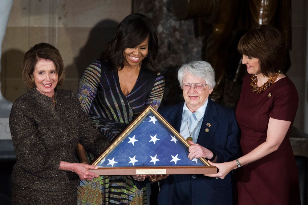 House Minority Leader Nancy Pelosi (D-CA) and First Lady Michelle Obama present an American flag to retired Air Force Brigadier Gen. Wilma Vaught on Capitol Hill, March 2, 2016 in Washington, DC. (Photo by Drew Angerer/Getty)