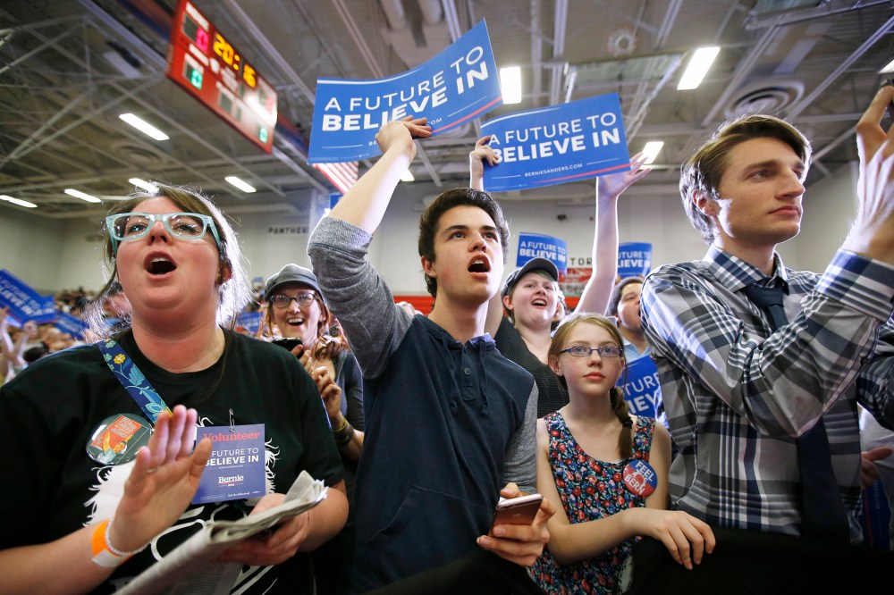 Supporters wave signs as Democratic presidential candidate Bernie Sanders speaks during a campaign rally at West High School on March 21, 2016 in Salt Lake City, Utah. (Photo by George Frey/Getty)