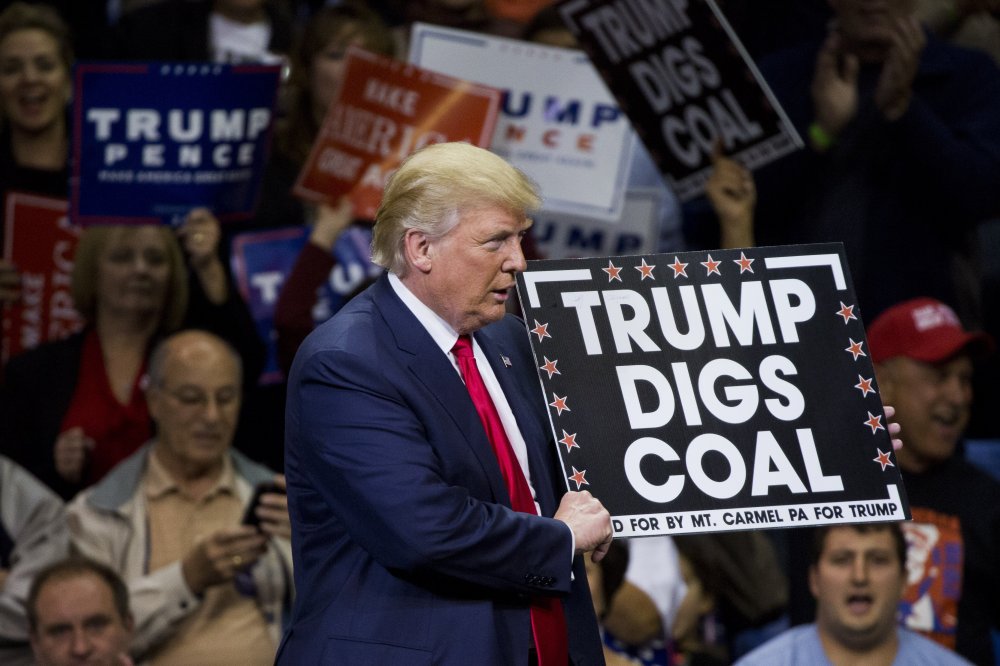 Republican presidential nominee Donald Trump holds a sign supporting coal during a rally at Mohegan Sun Arena in Wilkes-Barre, Pennsylvania on October 10, 2016.