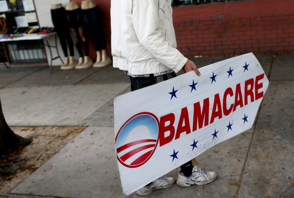 Pedro Rojas holds a sign directing people to an insurance company where they can sign up for the Affordable Care Act, also known as Obamacare, before the Feb. 15th deadline on Feb. 5, 2015 in Miami, Fl. (Photo by Joe Raedle/Getty)
