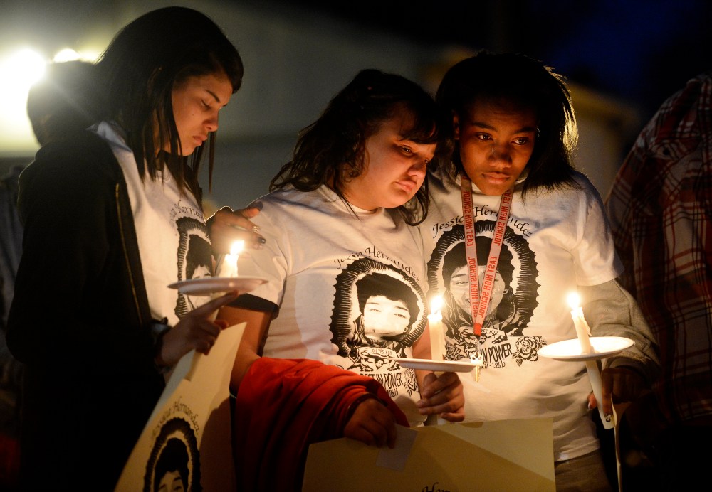 Zhakyra Cousin, center, Shia Brooks, left, and Markeesha McDade, right, during a Feb. 19, 2015 community vigil held in honor of Jessica Hernandez. (Photo by Andy Cross/The Denver Post via Getty)