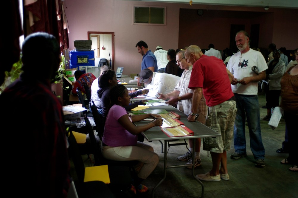 Voters line up to show identification before casting ballots at Deliverance Tabernacle Church of the Nazarene in Miami.