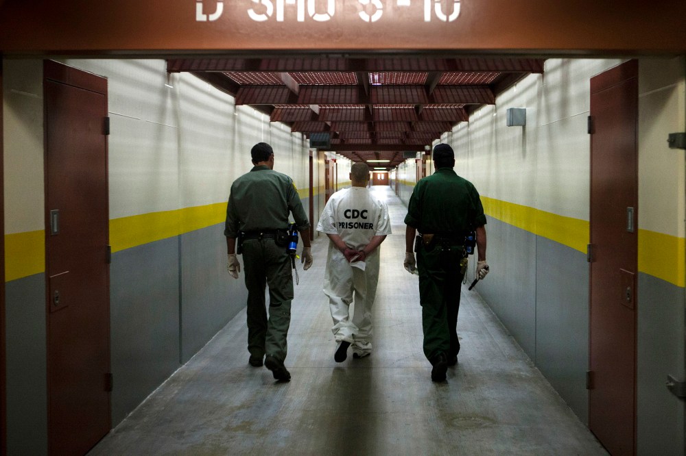 Two correction officers escort a prisoner down a corridor at Pelican Bay Prison in Crescent City, Calif. on June 8, 2012.