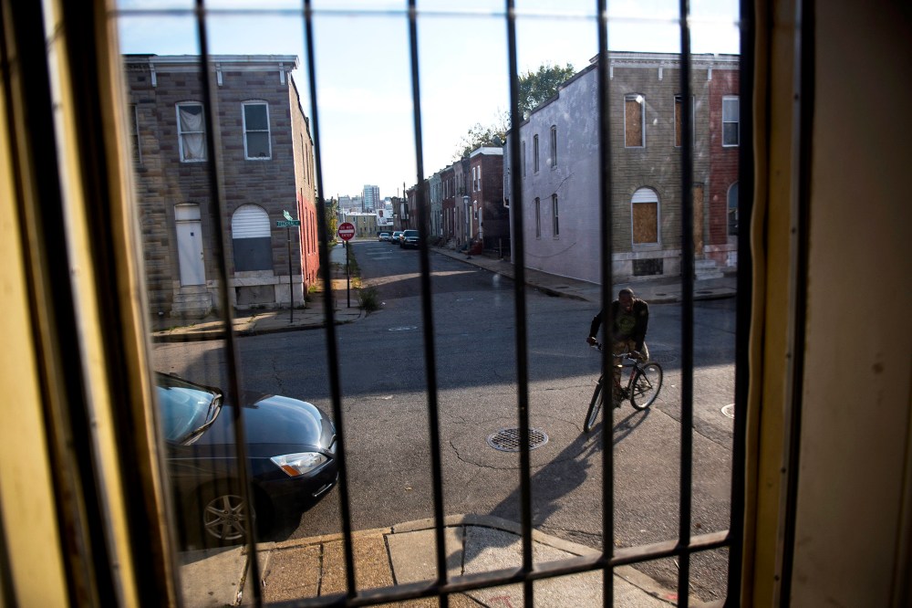 A resident rides his bike in an abandoned block in East Baltimore, Oct. 28, 2013.