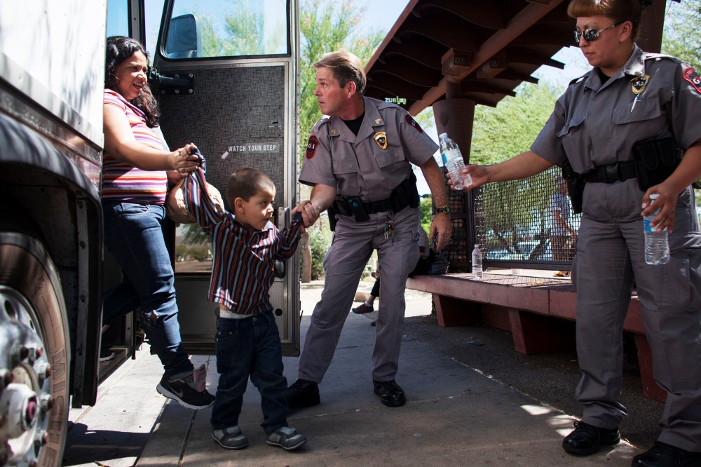 Immigrants who were bussed from Texas are released due to lack of manpower next to a Greyhound station in Phoenix, June 4, 2014.