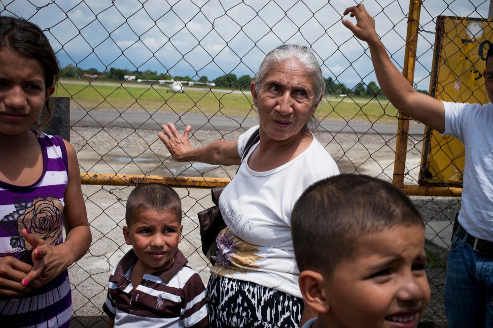 A family waits for a plane of migrants deported from the United States, arriving at Ramon Villeda Morales Airport in San Pedro Sula, Honduras, July 14, 2014.