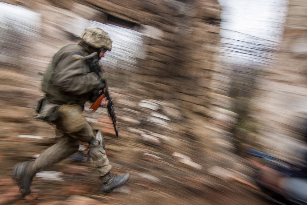 A Ukrainian serviceman runs as he patrols the area in Vodyanoe village, near Mariupol, Ukraine on Nov. 10, 2016. (Photo by Sergey Vaganov/EPA)
