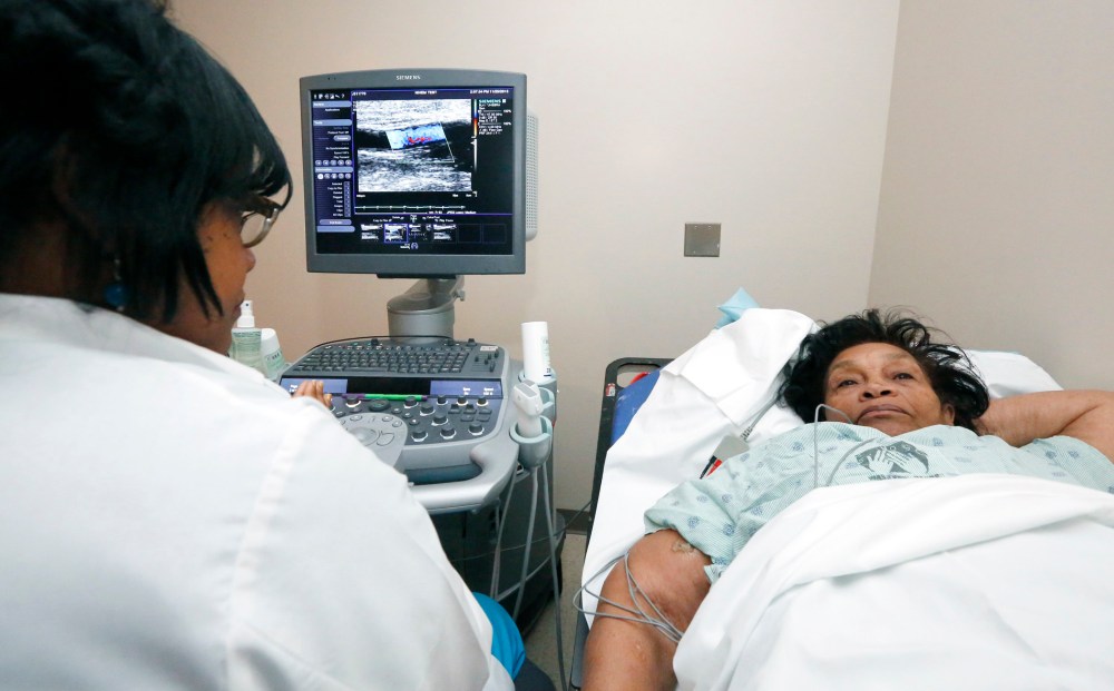 In this Nov. 25, 2013 photograph, Alberta Epps of Jackson, Miss., right, undergoes a sonogram of the brachial artery.