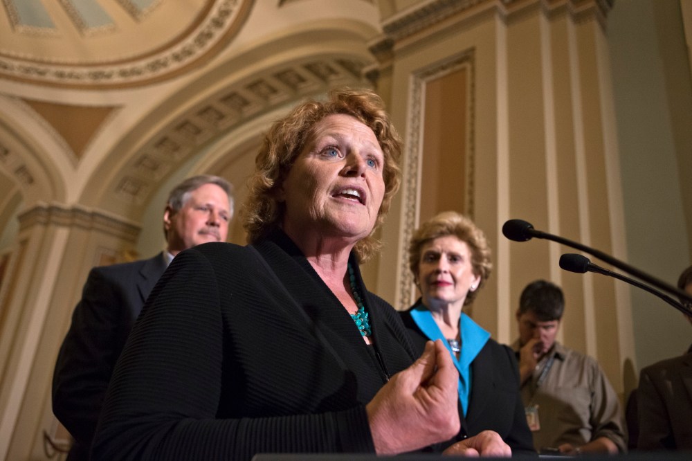 Sen. Heidi Heitkamp, D-N.D., center, joins Sen. Debbie Stabenow, D-Mich., chairwoman of the Senate Agriculture Committee, right, and Sen. John Hoeven, R-ND, left, to speak to reporters as the Senate votes on a farm bill that sets policy for farm...