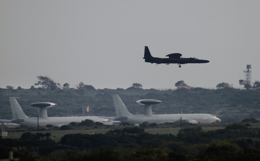 Two British RAF AWAC planes wait on the ground as another RAF plane flies past at Akrotiri a British military base.  Britain will send Typhoon and Tornado fighter jets to air bases to prevent Moammar Gadhafi's forces from mounting air strikes against...