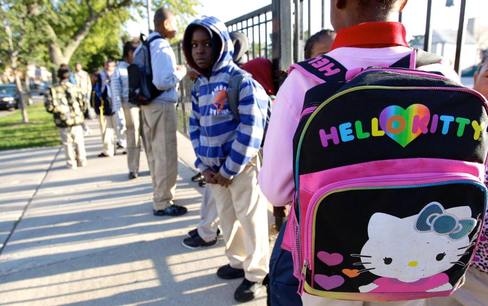 Students gather outside Benjamin E. Mays Academy in Chicago for the first day of school Wednesday morning, after Chicago teachers voted to suspend their first strike in 25 years.