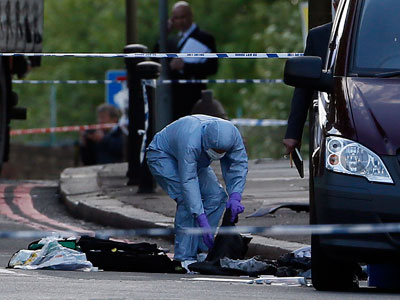 A police forensics officer investigates a crime scene where one man was killed in Woolwich, southeast London on May 22, 2013. (Photo by Stefan Wermuth/Reuters)
