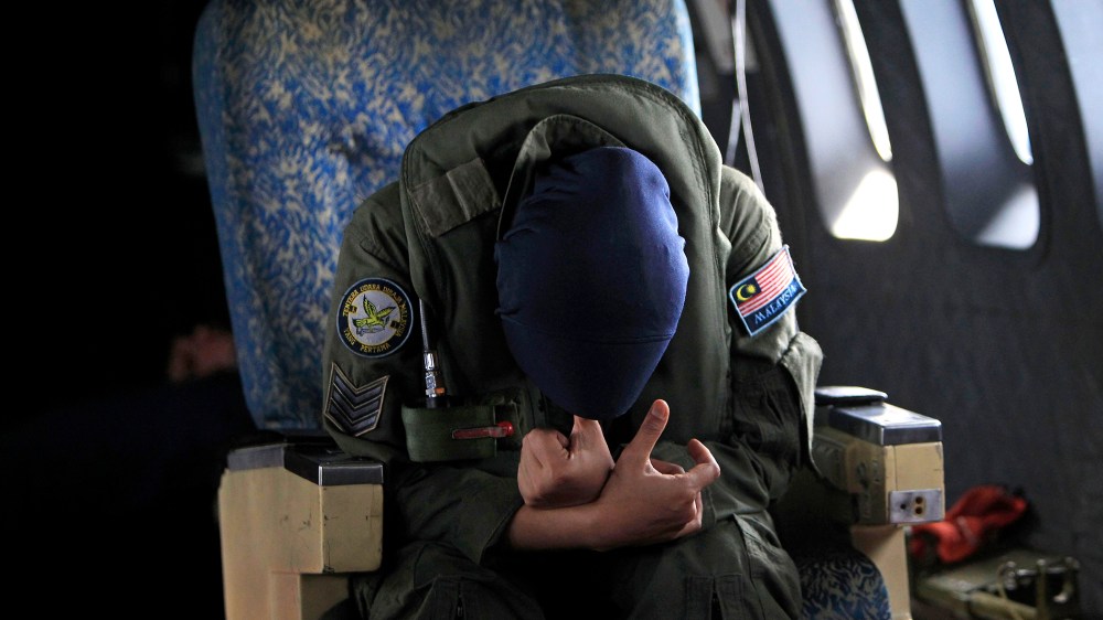 A crew member of a Royal Malaysian Air Force CN-235 aircraft rests after long hours working in a search and rescue operation for the missing Malaysia Airlines plane over the Straits of Malacca, Thursday, March 13, 2014.