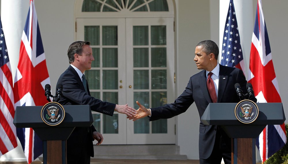 British Prime Minister David Cameron and President Barack Obama reach to shake hands during their joint news conference in the Rose Garden of the White House in Washington Wednesday, March 14, 2012