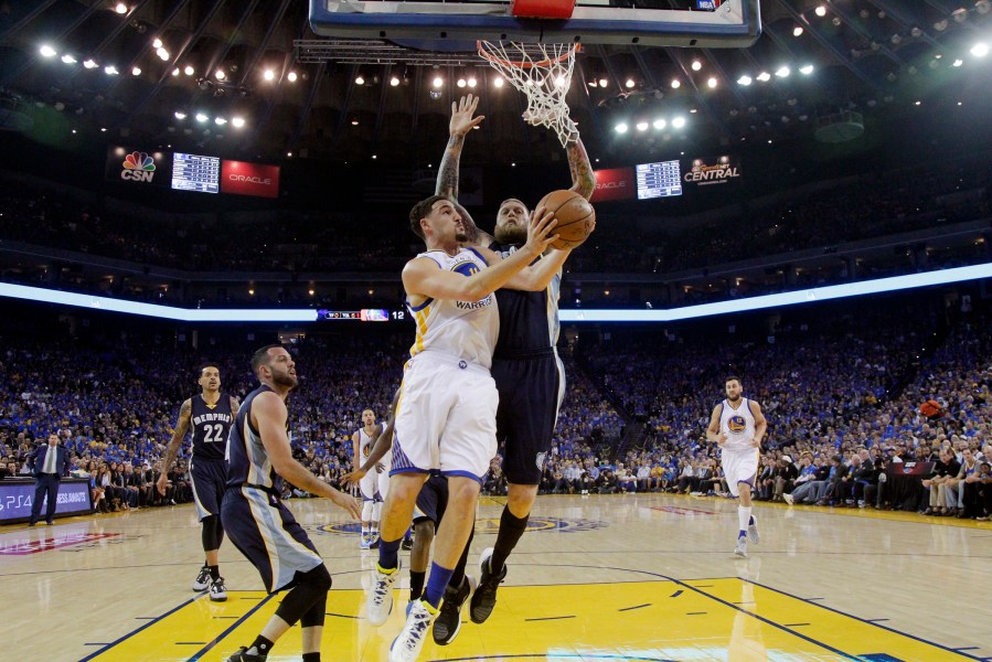 Golden State Warriors' Klay Thompson, center, drives to the basket as Memphis Grizzlies' Chris Andersen defends during the first half of an NBA basketball game, April 13, 2016, in Oakland, Calif. (Photo by Marcio Jose Sanchez/AP)