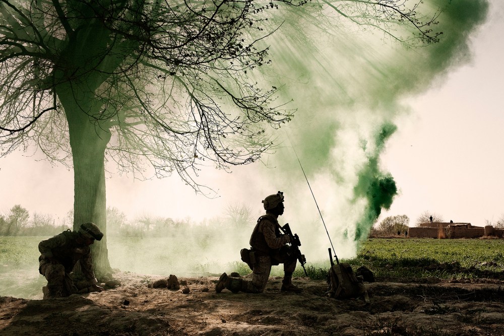 US Marines kneel behind a smoke screen at a helicopter landing zone in Marja, Afghanistan, March 2010.