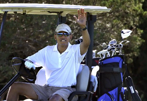President Barack Obama waves to a group of on-lookers while golfing at Farm Neck Golf Club in Oak Bluffs, Mass., on the island of Martha's Vineyard, Sunday, Aug. 11, 2013. (AP Photo/Steven Senne)