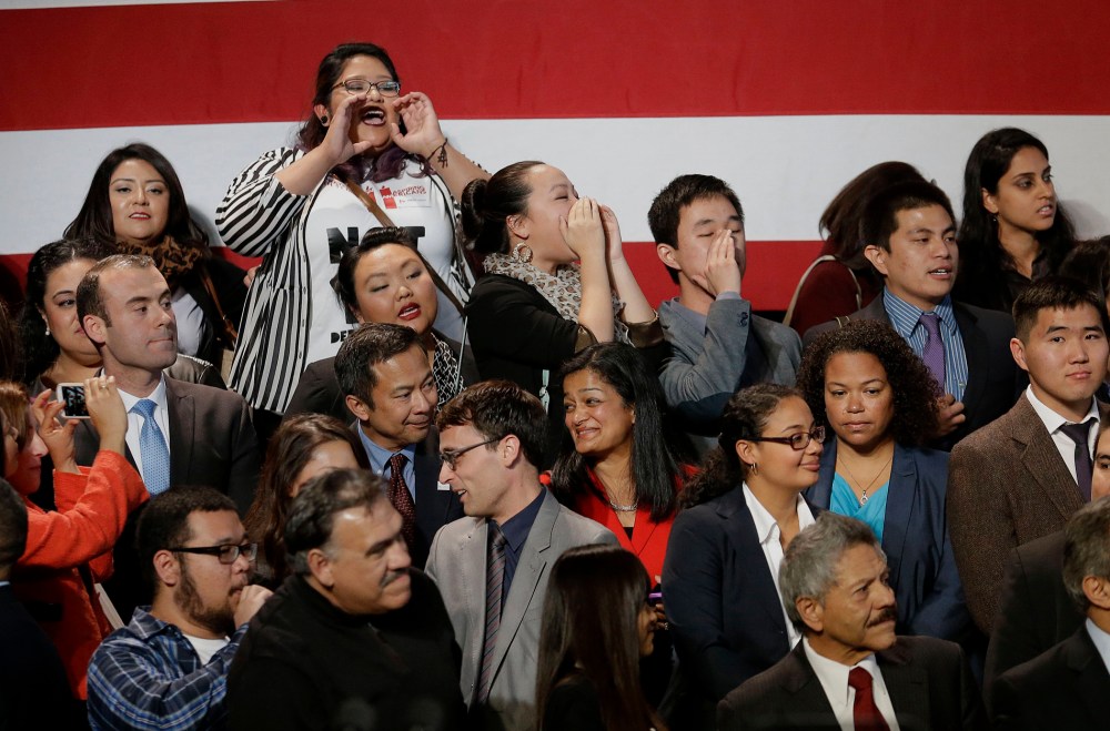 A group yells immigration reform chants at President Barack Obama as he leaves after speaking about immigration reform, Monday, Nov 25, 2103, at the Betty Ann Ong Chinese Recreation Center in San Francisco.