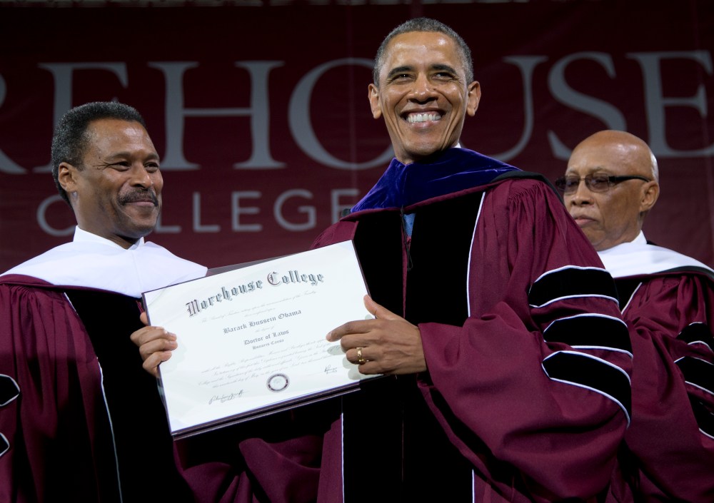 Morehouse College President John Silvanus Wilson Jr. stands left and Robert Davidson, Chair of the Board of Trustees, right, as President Barack Obama holds his honorary a doctorate of laws degree during the Morehouse College 129th Commencement...