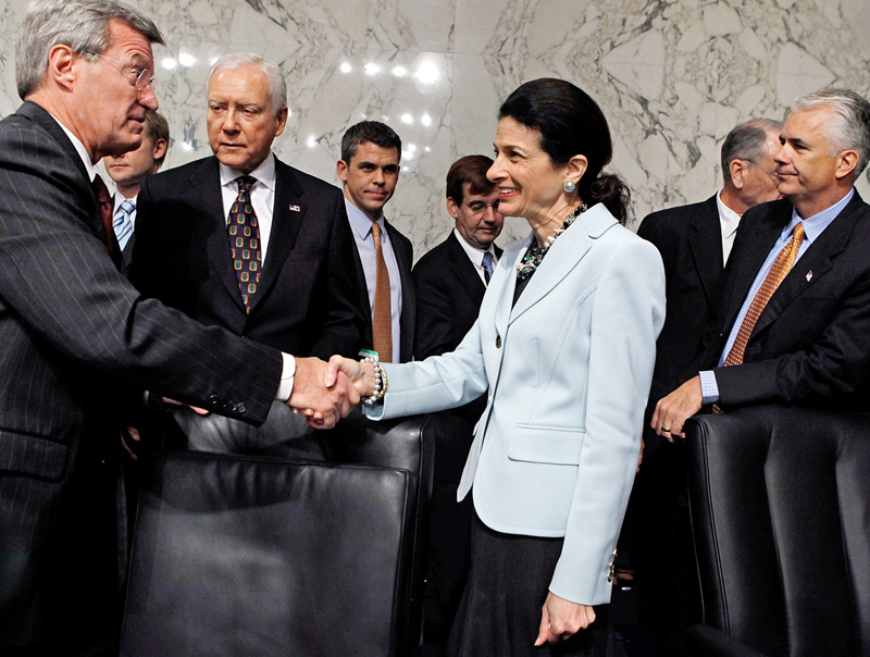 Senate Finance Committee Chairman Max Baucus (D-MT) (L) thanks  Sen. Olympia Snowe (R-ME) for voting in favor of health care reform legislation as committee Republicans Sen. Orrin Hatch (R-UT) and Sen. John Ensign (R-NV) watch, on Capitol Hill October...