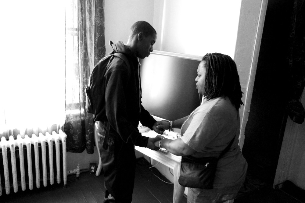 Khyrie Hawkins, 13, and his mother Dawn Hawkins pray in their Philadelphia home