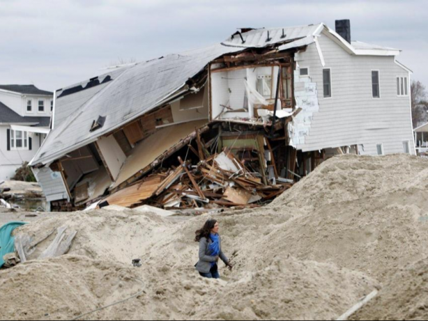 Sea Bright Mayor Dina Long walks along Ocean Avenue past a destroyed house that was knocked off its foundation during Hurricane Sandy, as seen on November 1, 2012 in Sea Bright, New Jersey.  (Photo by Aristide Economopoulos/The Star-Ledger via Corbis)