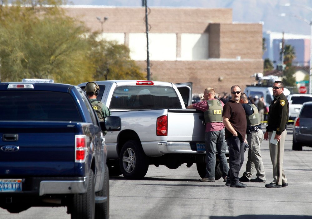Las Vegas Metro Police officers and FBI agents stand in the street after a stand-off in Las Vegas on Feb. 19, 2015.
