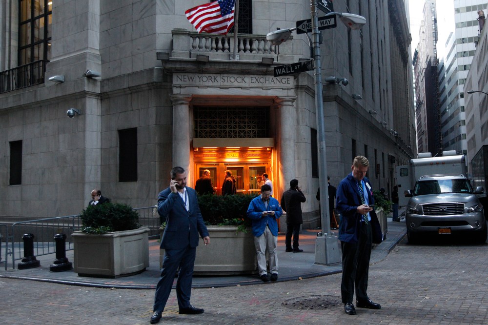 Traders stand outside the New York Stock Exchange prior to the opening bell.
