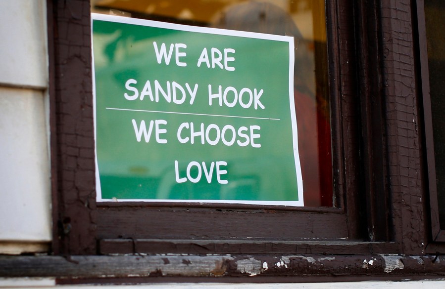 A sign hangs in a window of the Sandy Hook Diner in Newtown, Conn.