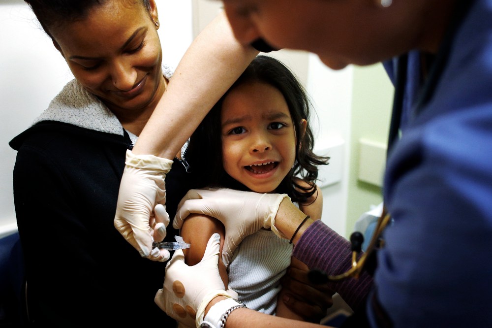 Mercado sits in his mother's lap while getting an influenza vaccine at Boston Children's Hospital in Boston
