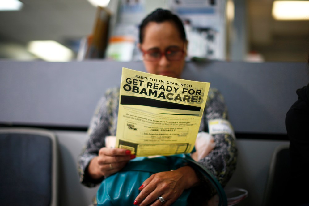 A woman reads a leaflet at a health insurance enrollment event in Cudahy, California March 27, 2014.