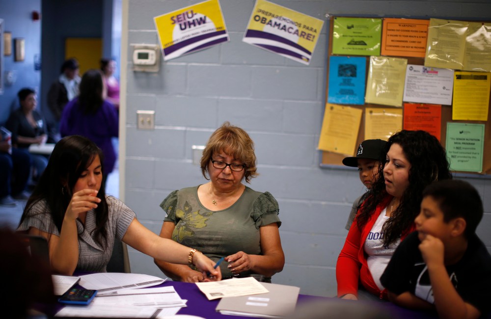Maria Renteria (L), explains health insurance options to Manuela Ruiz and her daughter at an enrollment event in Cudahy, California March 27, 2014.