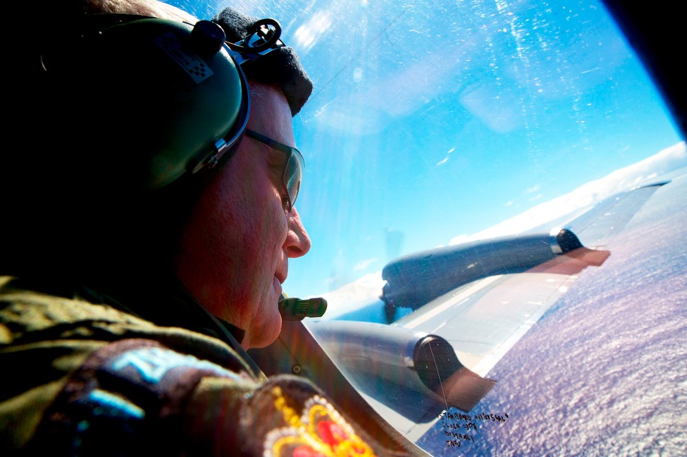 Sergeant Trent Wyatt looks out an observation window aboard a Royal New Zealand Air Force search aircraft as it flies over the southern Indian Ocean looking for debris from missing Malaysian Airlines flight MH370, April 11, 2014.