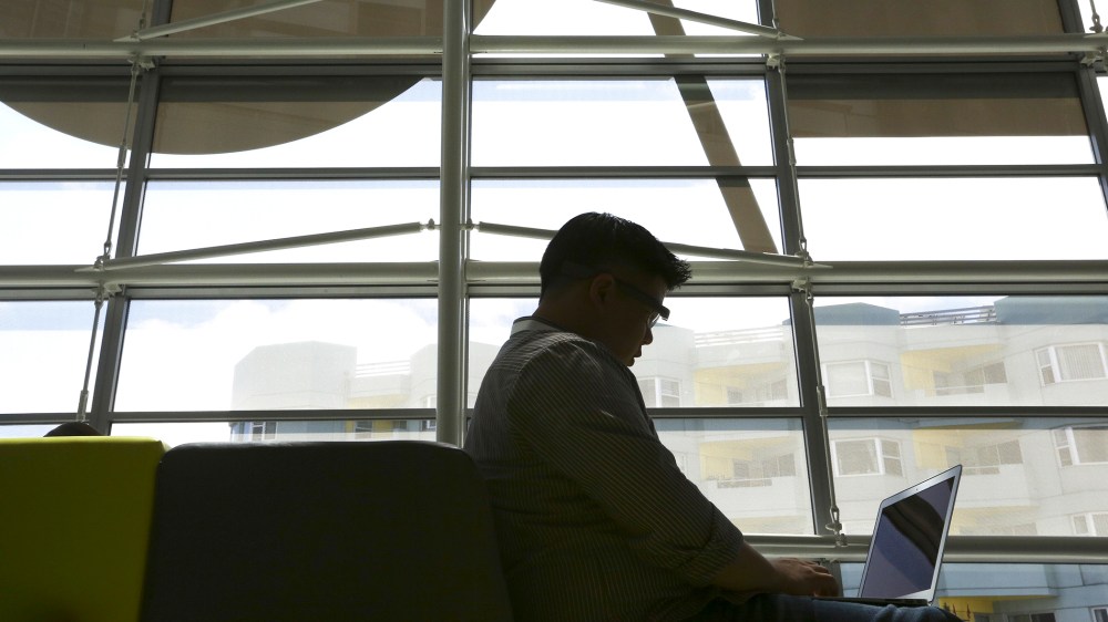 An attendee wearing Google Glass uses his laptop at the Google I/O developers conference in San Francisco