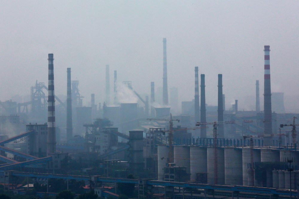 A steel factory is seen in smog during a hazy day in Anshan, Liaoning province, China on June 29, 2014.