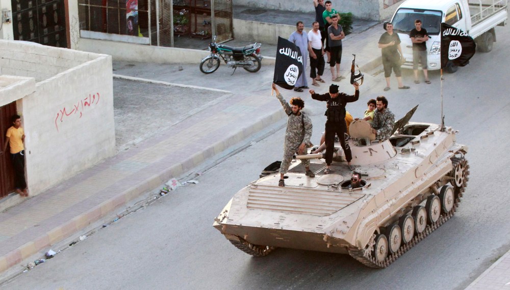 Militant Islamist fighters take part in a military parade along the streets of northern Raqqa province June 30, 2014.