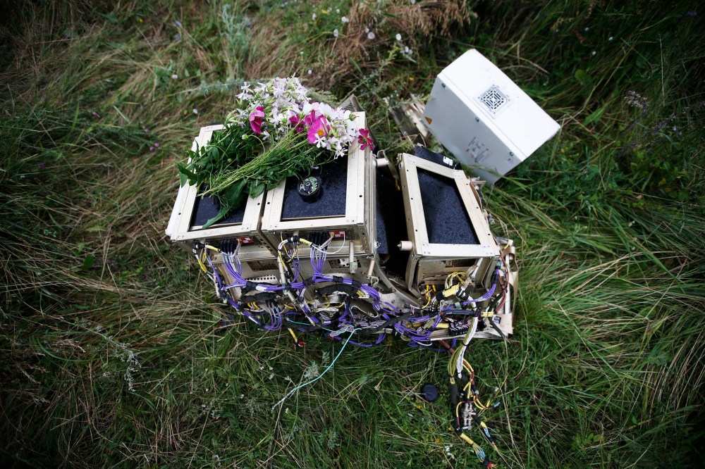 Flowers lie on debris from a Malaysian Airlines Boeing 777 plane which was downed on Thursday near the village of Rozsypne, in the Donetsk region July 18, 2014.