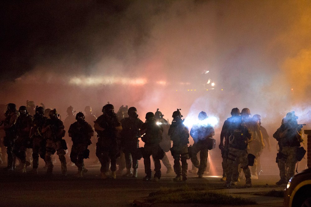 Riot police clear demonstrators from a street in Ferguson, Mo., Aug. 13, 2014. (Photo by Mario Anzuoni/Reuters)