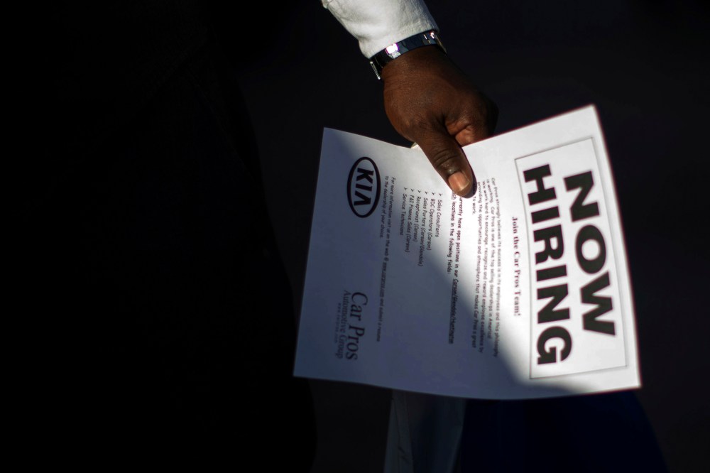 A man holds a leaflet at ' job fair in Carson, Calif. on Oct. 3, 2014