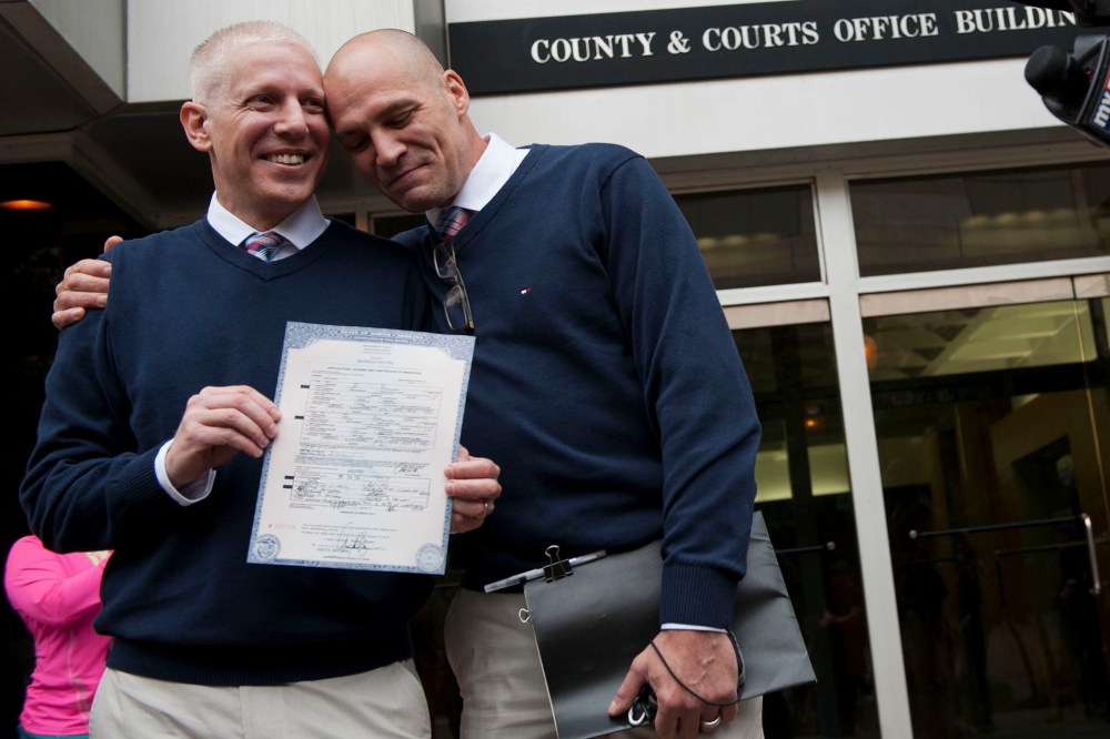 Terrence Hall (L) and Christopher DeCaria (R) display their marriage license to the media outside of the Mecklenburg County Register of Deeds office in Charlotte, North Carolina, on Oct. 13, 2014.