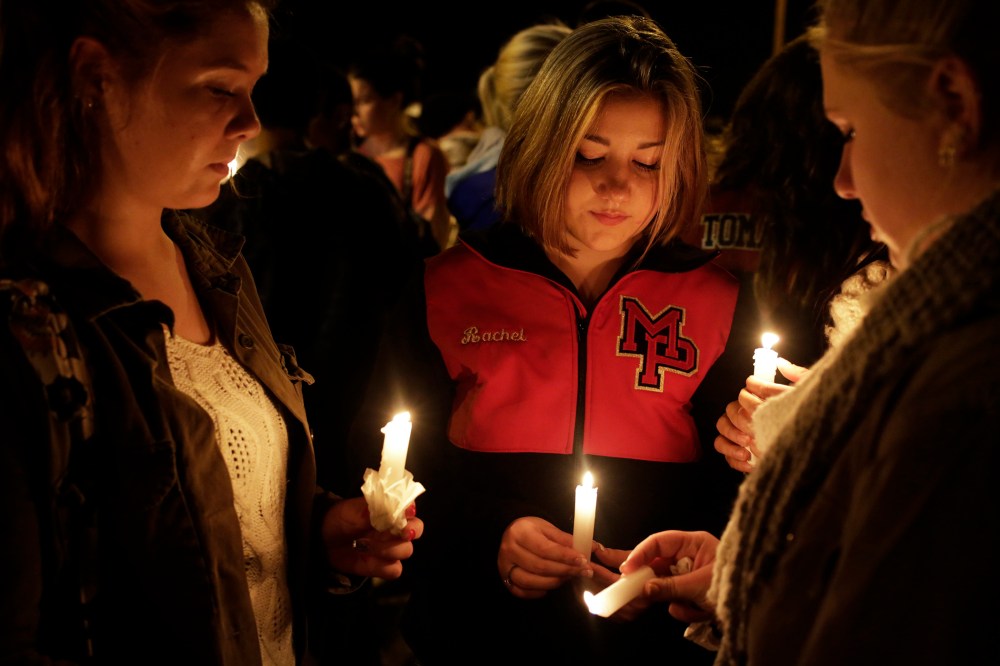 Katelynn Janisko (L-R), 15, Rachel Cowan, 15, and Jamison Strickland, 15, light candles at a vigil after a shooting at Marysville-Pilchuck High School in Marysville, Wash., Oct. 24, 2014. (Photo by Jason Redmond/Reuters)
