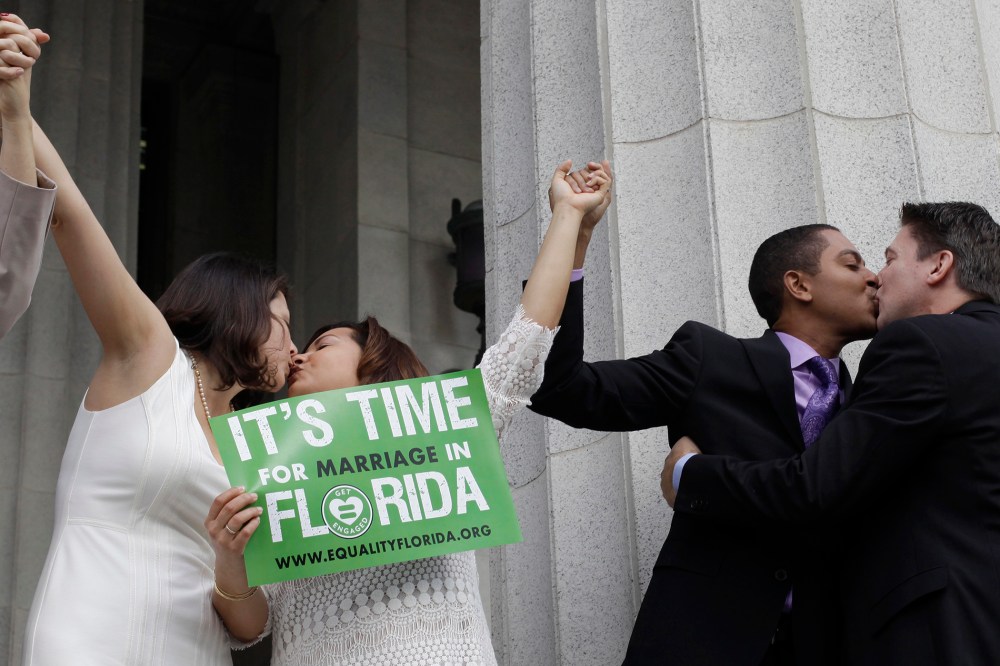 From right to left; Jeff Delmay, Todd Delmay, Karla Arguello and Catherina Pareto kiss after the same-sex couples were married in Miami, Fla. on Jan. 5, 2015. (Photo by Javier Galeano/Reuters)