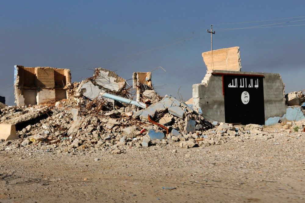 A destroyed building with a wall painted with the black flag commonly used by Islamic State militants is seen, March 10, 2015. (Photo by Thaier Al-Sudani/Reuters)