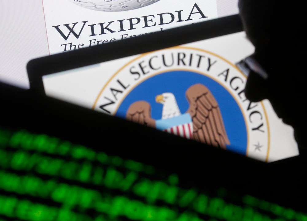 A man is seen near cyber code and the U.S. National Security Agency logo in this photo illustration taken in Sarajevo March 11, 2015. (Photo by Dado Ruvic/Reuters)