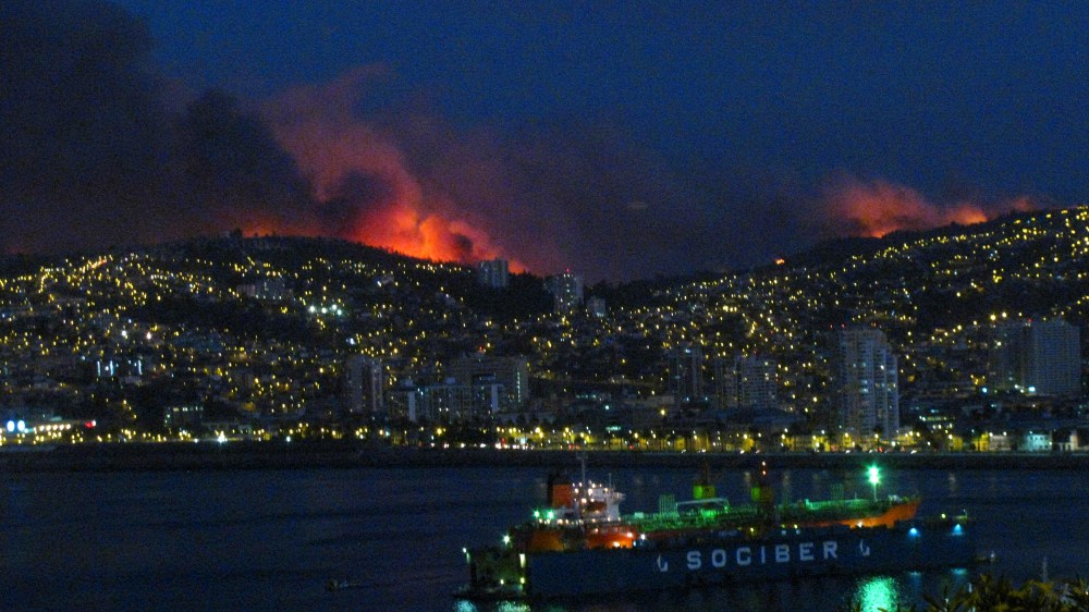 Smoke from a forest fire is seen in Valparaiso city, northwest of Santiago, Chile, March 13, 2015. A forest fire was raging out of control on Friday evening into Saturday, threatening the Chilean port city of Valparaiso. (Photo by Lucas Alvarado/Reuters)