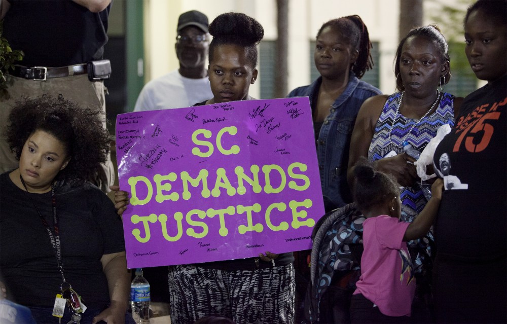 A protester holds a sign during a late rally at city hall in North Charleston, SC, April 8, 2015. (Photo by Randall Hill/Reuters)