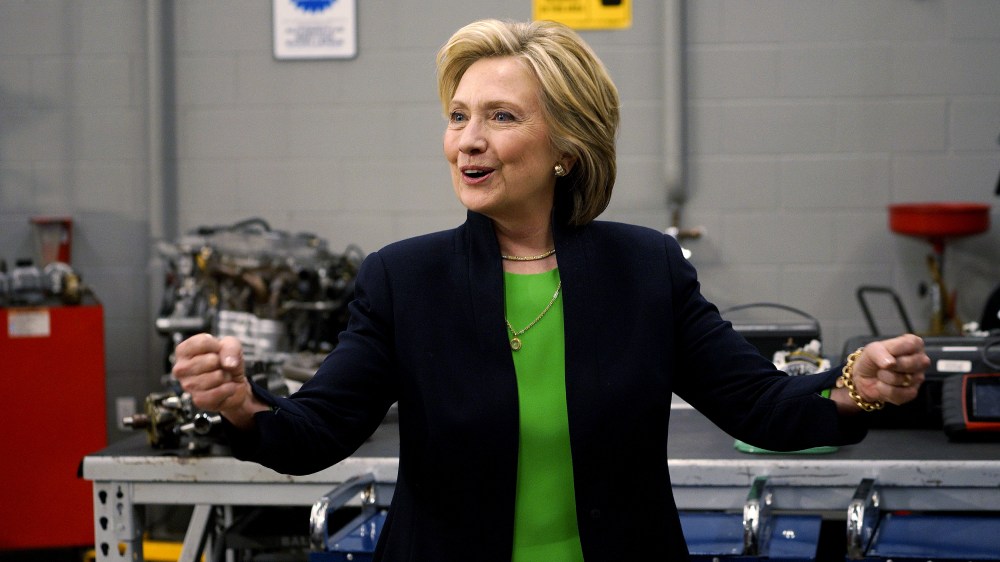 Former US Secretary of State Hillary Clinton pumps her fists in an auto shop as she campaigns for the 2016 Democratic presidential nomination at Kirkwood Community College in Monticello, Ia., April 14, 2015. (Photo by Rick Wilking/Reuters)