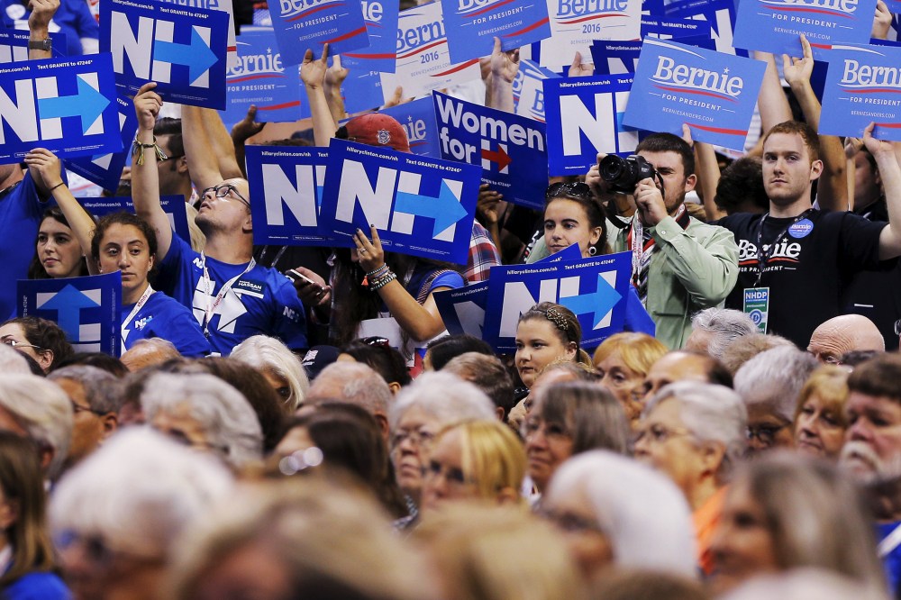 A divided crowd of supporters hold up signs at the New Hampshire Democratic Party State Convention in Manchester, NH. Sept. 19, 2015. (Photo by Brian Snyder/Reuters)
