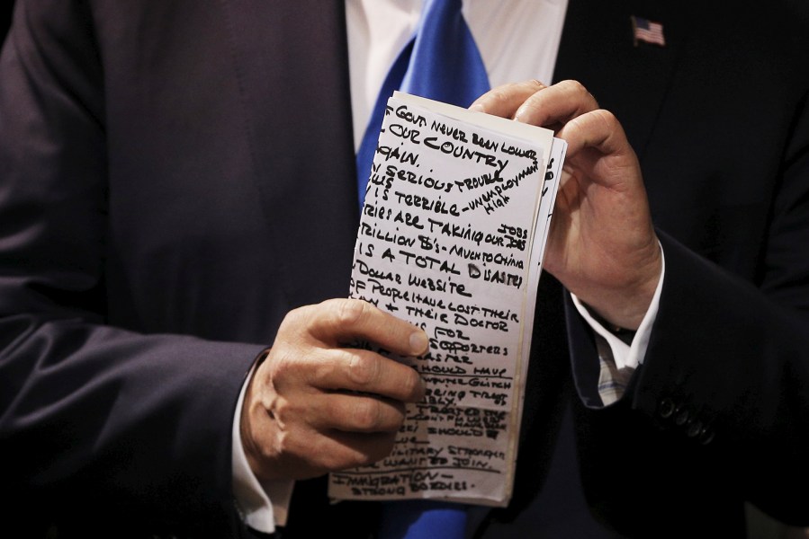 U.S. Republican presidential candidate Donald Trump checks his notes before speaking at one of the New England Council's 