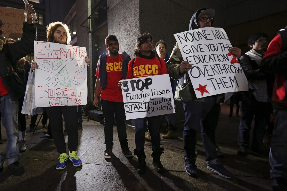 Students hold up signs as they attend a demonstration calling for lower tuition at Hunter College in Manhattan, New York, Nov. 12, 2015. (Photo by Carlo Allegri/Reuters)